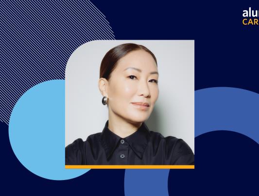Headshot of Jennifer Wong wearing a black collared shirt over a blue background