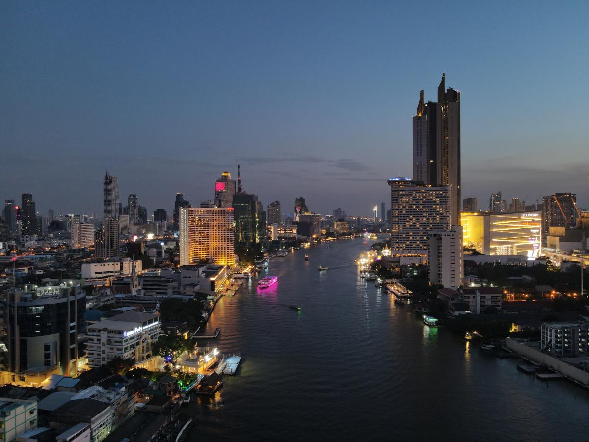 Aerial shot of Chao Phraya River at night, with buildings on either side