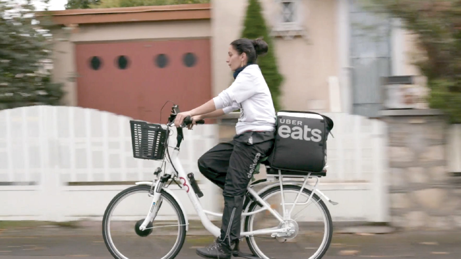 An uber worker rides her bike during a delivery. 