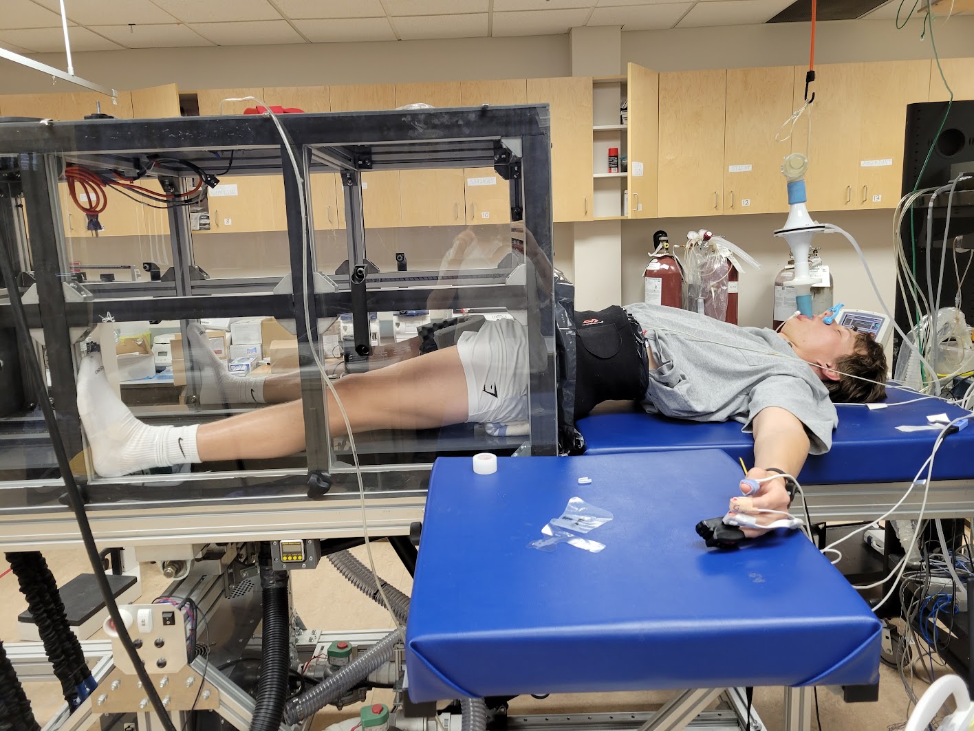 Here, Monteleone lies in a lower body negative pressure chamber. This is used to simulate blood loss and physiologically stress the body’s cardiovascular system. Reflex increases in heart rate and blood pressure can be manipulated and observed in a well-controlled manner, making the device an important tool for physiological research.