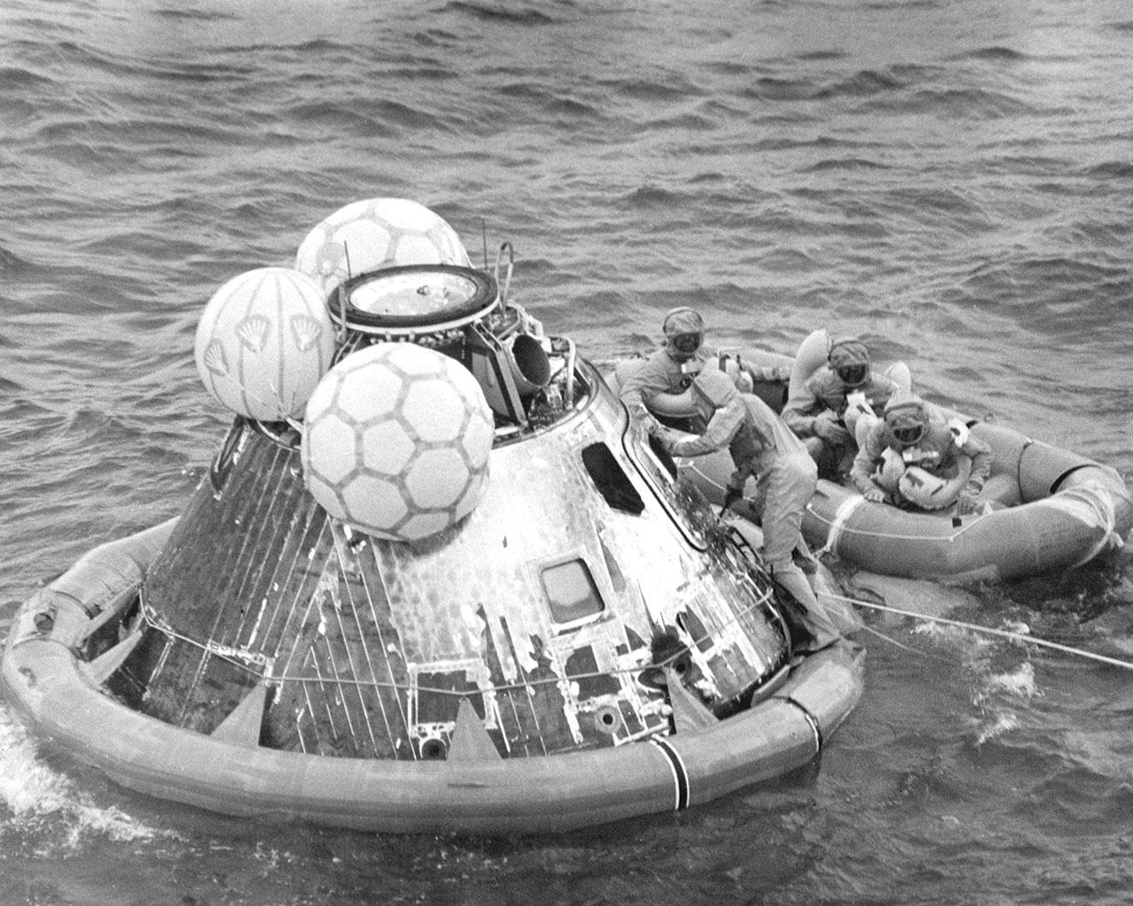 After splashdown in the Pacific Ocean, the Apollo 11 astronauts wait in the life raft as a pararescue man closes and secures the capsule hatch. The crew was then air lifted to the prime recovery ship, the USS Hornet, where they were housed in a Mobile Quarantine Facility (MQF). Image credit: NASA (Milt Putnam)