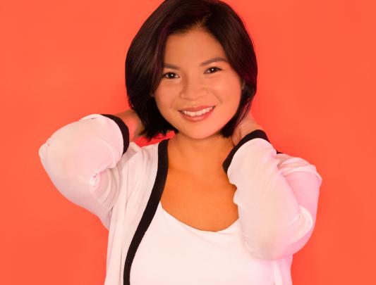 A picture of Kookai Chaimahawong, smiling, against an orange background.