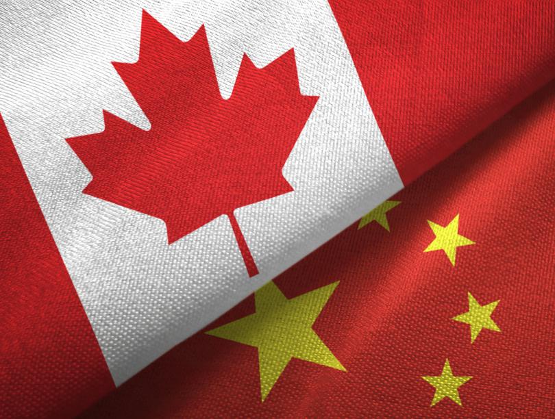 A portion of the Canada and China flags, overlapping each other.