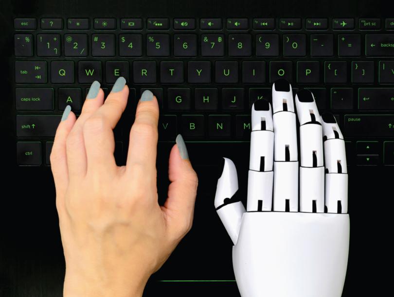 Human left hand beside a robotic right hand