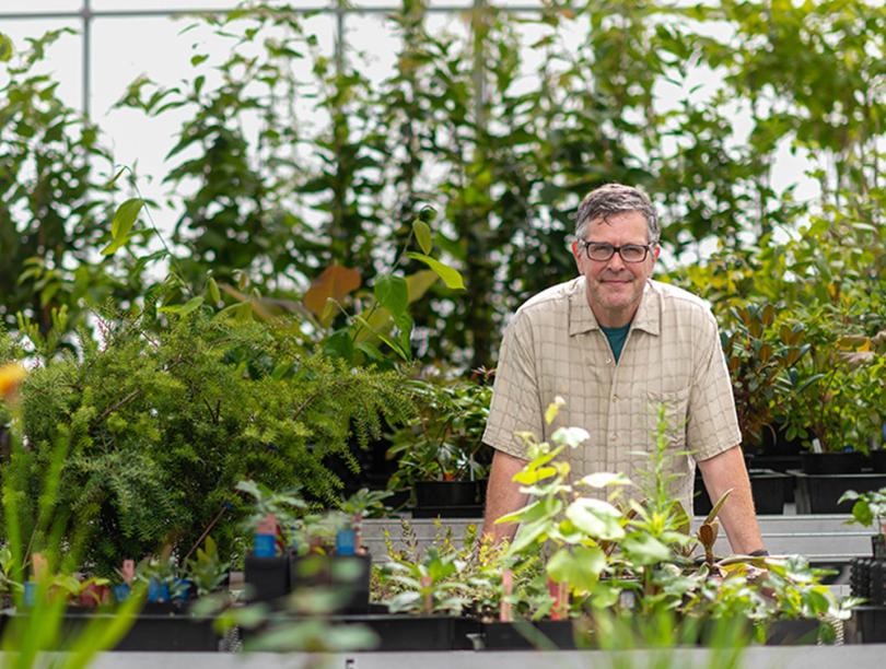 Kevin Kubeck standing among plants in a nursery