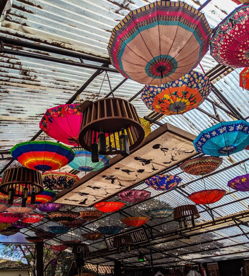 Colourful umbrellas suspended from a ceiling at an art exhibition in Nairobi