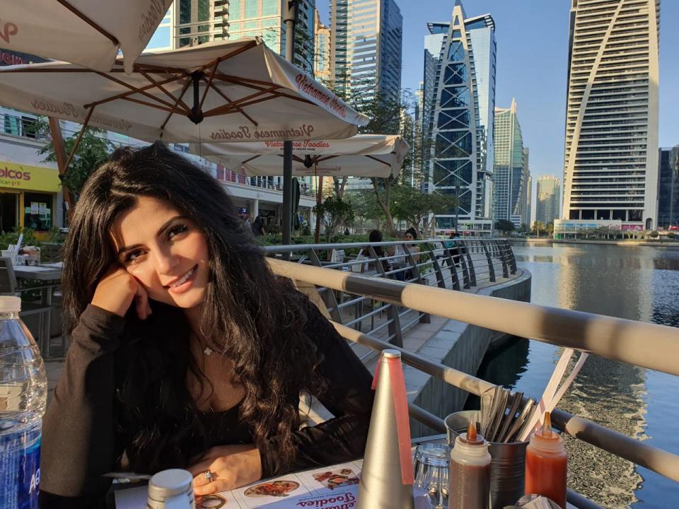 Leanne Rachid seated at a cafe table outdoors at the Dubai Marina