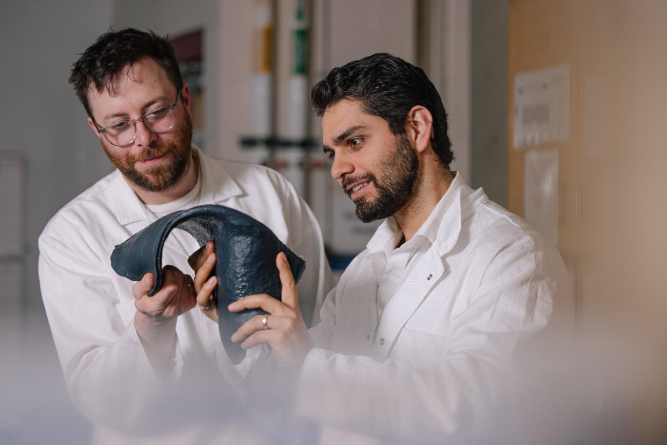 Two scientists handle sheet of bioplastic