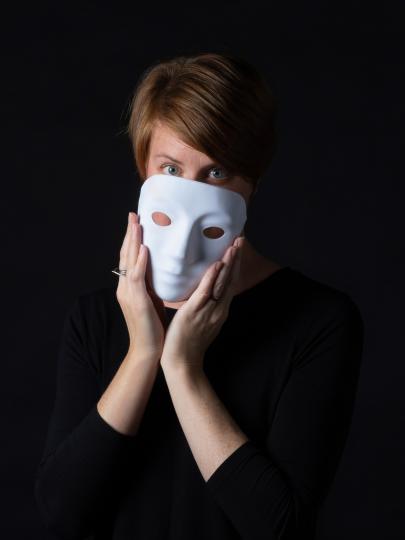 Dr. Leanne ten Brinke holding a white mask over her face